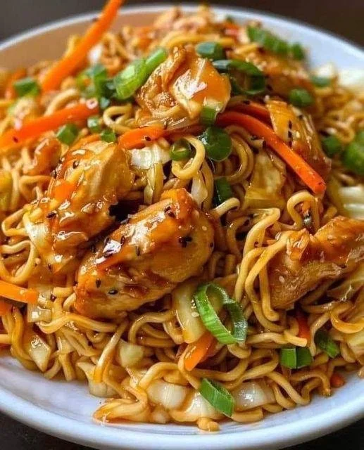 Chinesisch gebratene Nudeln mit Hühnchenfleisch auf einem Teller serviert