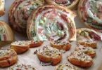 Leckeres Flammkuchen Roll serviert auf einem Holzbrett.