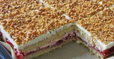 Frankfurter Kranz Schnitten auf einem Teller, dekoriert mit Kirschen und Sahne.