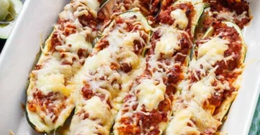 Leckere gefüllte Zucchini mit Gemüse und Käse auf einem Teller.