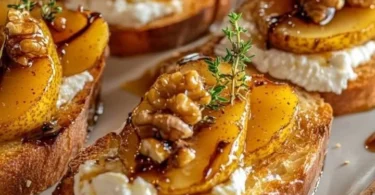 Karamellisierte Birnen Ziegenkäse-Crostini auf einem Holzbrett serviert