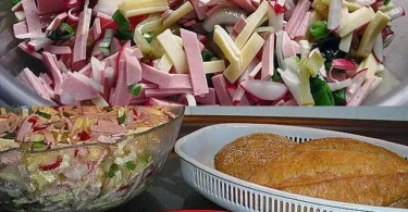 Frischer Käse-Wurst-Salat mit buntem Gemüse auf einem Teller angerichtet