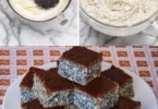 Mohnkuchen mit Schokoladenglasur auf einem Teller serviert.
