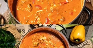 Schüssel mit Pizzasuppe, belegt mit Käse und frischen Kräutern.