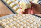 Leckere Plätzchen in verschiedenen Formen und Farben auf einem Blech