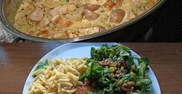 Schweinefilet in Sahnesoße auf einem Teller garniert mit frischen Kräutern