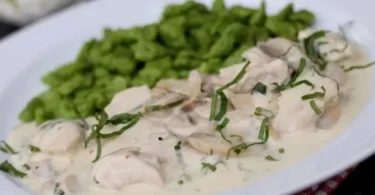 Türkische Pfanne mit Pilzen und Frischkäse auf einem Teller angerichtet