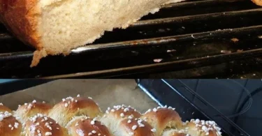 Frisch gebackenes Zopfbrot auf einem Holzbrett, dekoriert mit Sesam.