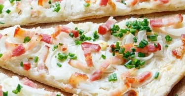 Traditioneller Elsässer Flammkuchen mit Speck und Zwiebeln auf dünnem Teig