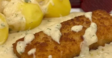 Backfisch in Senfsauce auf einem Teller serviert