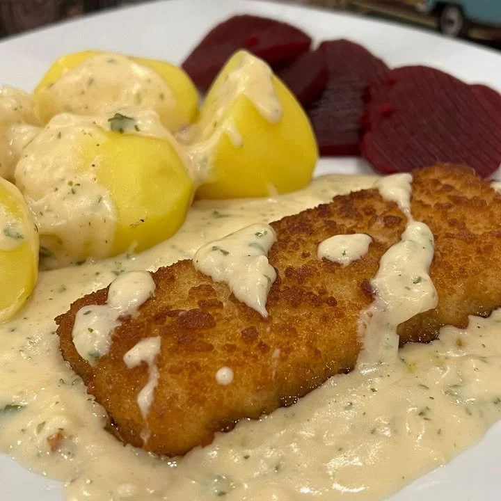 Backfisch in Senfsauce auf einem Teller serviert