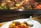 Fleischbällchen mit knusprigen Kartoffelspalten auf einem Teller serviert