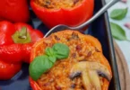 Gefüllte Paprika mit Tomatenreis auf einem Teller, vegetarisches Gericht.