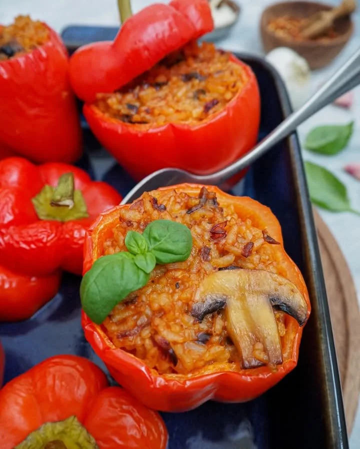 Gefüllte Paprika mit Tomatenreis auf einem Teller, vegetarisches Gericht.