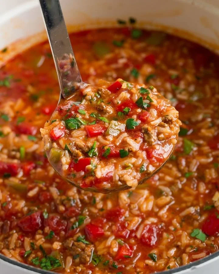 Schüssel mit gefüllter Paprikasuppe, dekoriert mit frischen Kräutern.