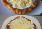 Leckere Langos mit Knoblauchöl und Crème Fraîche, serviert auf einem Teller.