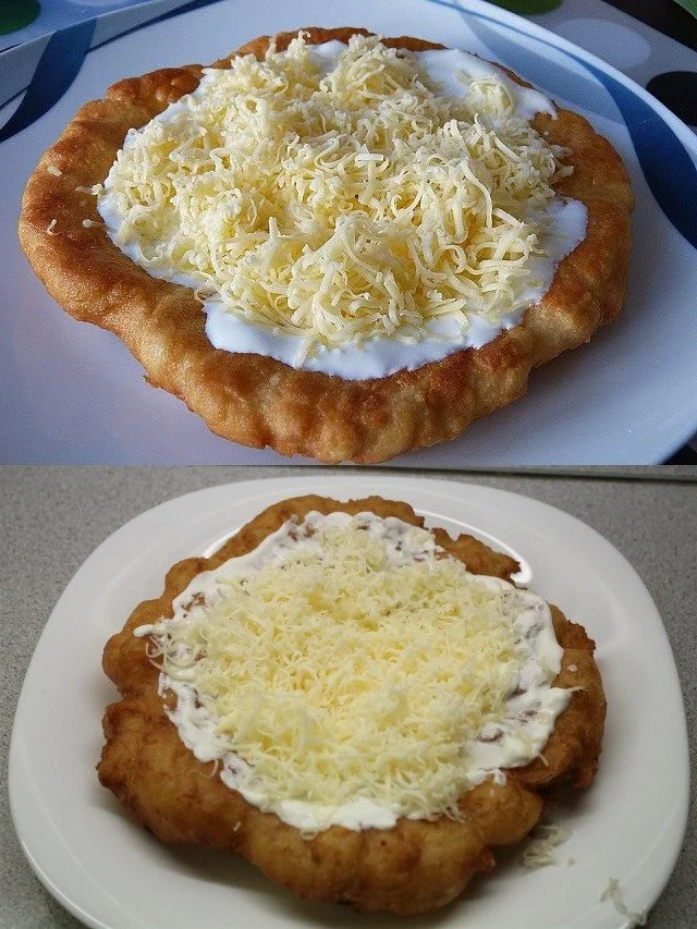 Leckere Langos mit Knoblauchöl und Crème Fraîche, serviert auf einem Teller.