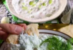 Quark-Dip mit Gurke auf einem Teller, ideal als Snack oder Dip.