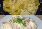 Tortellini mit Käsesahnesauce serviert auf einem Teller