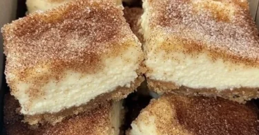 Zimtkäsekuchen mit Zimtstaub auf einem Teller, dekoriert mit frischem Obst
