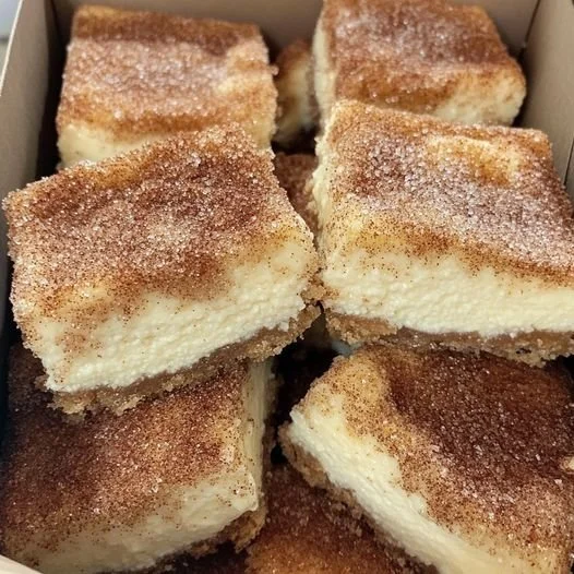 Zimtkäsekuchen mit Zimtstaub auf einem Teller, dekoriert mit frischem Obst