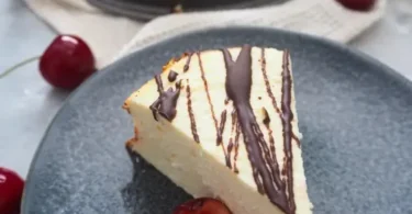 Zuckerfreier Kokosquarkkuchen auf einem Teller mit frischen Früchten.