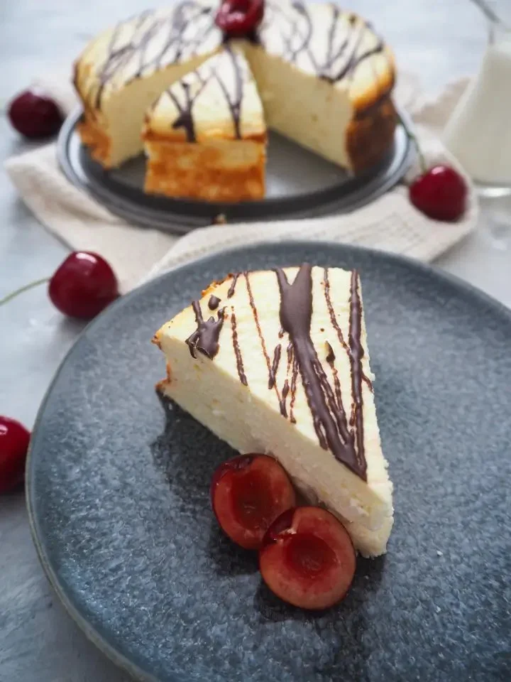 Zuckerfreier Kokosquarkkuchen auf einem Teller mit frischen Früchten.
