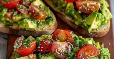 Leckeres Avocadobrot mit frischen Tomaten auf einem Holzbrett