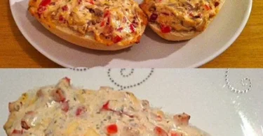 Belegte Brötchen mit Frischkäse auf einem Holzbrett serviert