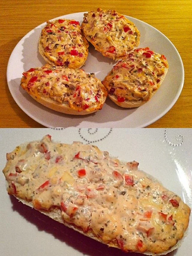 Belegte Brötchen mit Frischkäse auf einem Holzbrett serviert