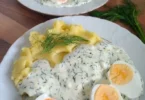 Eier in Dillsoße mit Kartoffeln auf einem Teller serviert