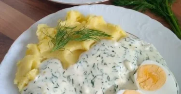 Eier in Dillsoße mit Kartoffeln auf einem Teller serviert