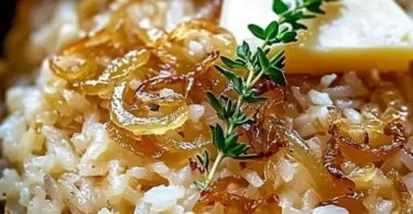 Schüssel mit französischem Zwiebelbutterreis, verfeinert mit Zwiebeln und Kräutern.
