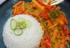Indisches Gemüse-Curry mit Reis in einer bunten Schüssel serviert