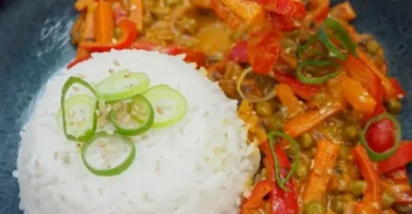 Indisches Gemüse-Curry mit Reis in einer bunten Schüssel serviert