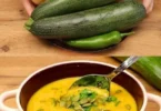 Schüssel mit Karotten-Zucchini-Suppe, gesund und lecker zubereitet.