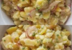 Ein delikater Kartoffelsalat mit frischem Gemüse und Dressing