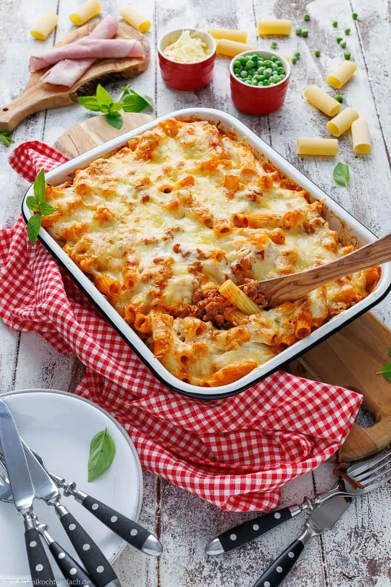 Leckere Portion Rigatoni al forno, frisch aus dem Ofen, serviert mit Käse und Kräutern.