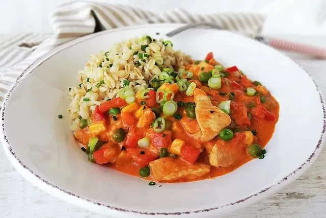 Türkisches Hähnchen mit Ajvar und Ebly auf dem Teller serviert.
