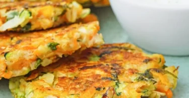 Zucchini-Fritter mit Hafer und Karotten auf einem Teller serviert