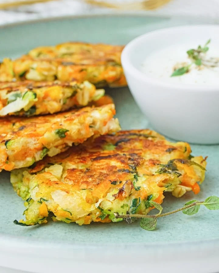 Zucchini-Fritter mit Hafer und Karotten auf einem Teller serviert