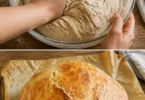 Frisches Hausbrot auf Holzbrett mit frischen Kräutern
